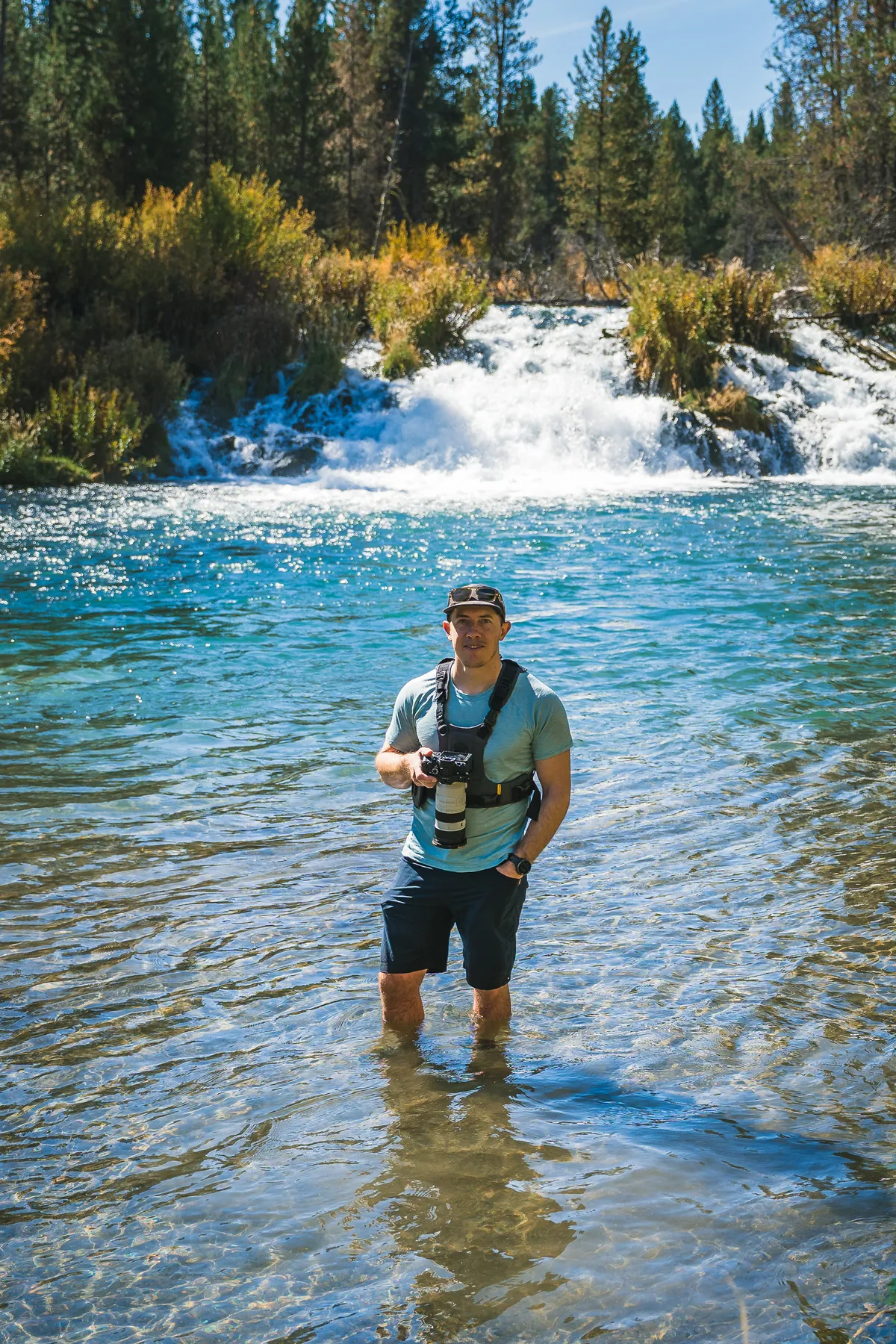 Justin knee-deep in a cold creek photographing the La Pine Loop Adventure Race